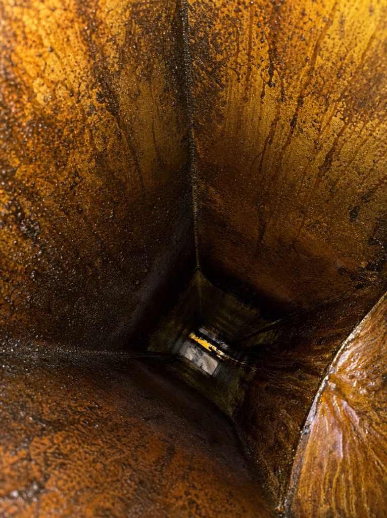 Kitchen exhaust duct and riser section with heavy grease buildup before AFS cleaning