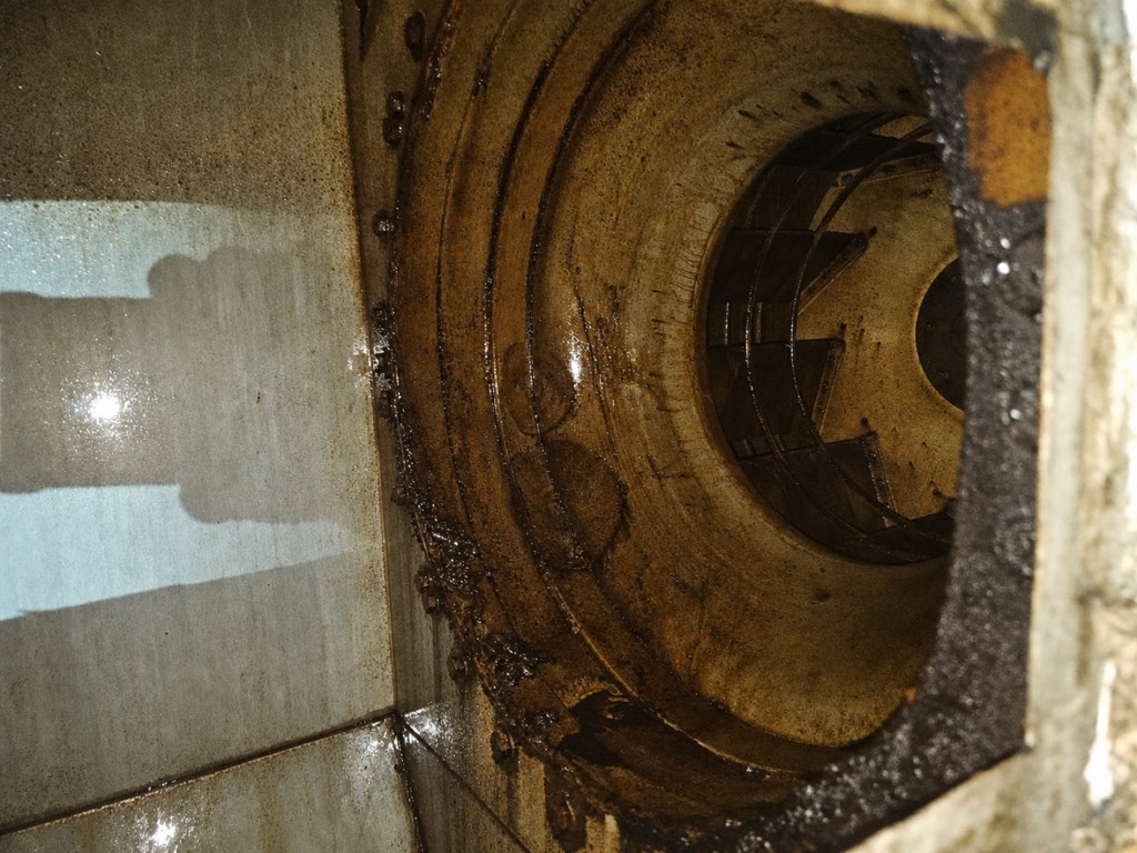 Rooftop exhaust fan interior with heavy grease accumulation before AFS cleaning
