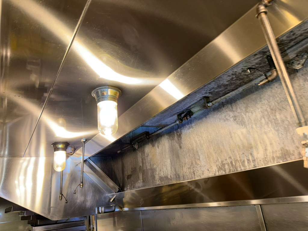 Commercial hood canopy with grease buildup before AFS cleaning
